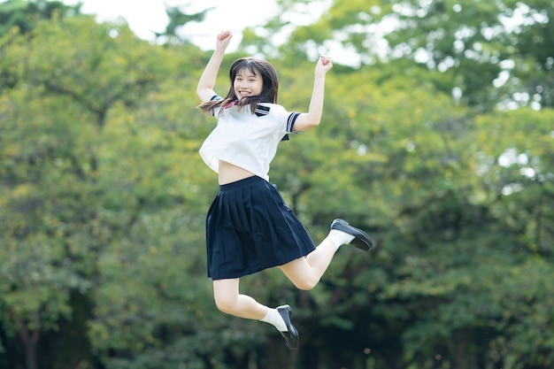 Aluna asiática do ensino médio brincando com um sorriso no parque