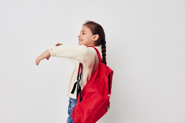 Foto aluna bonita com mochila vermelha posando estilo de vida inalterado