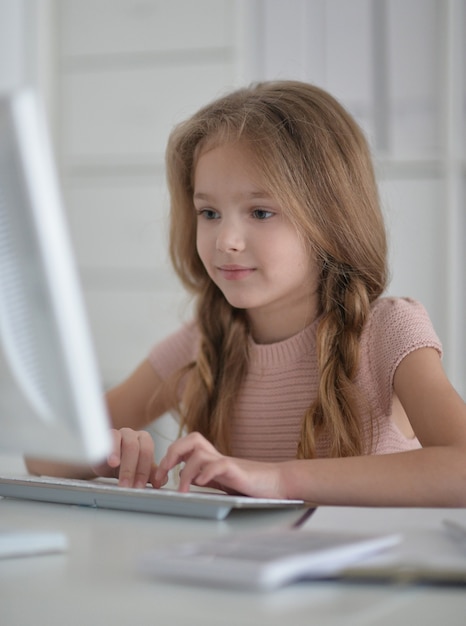 Aluna bonitinha fazendo lição de casa usando o computador