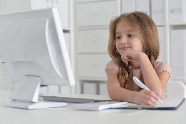 Aluna bonitinha fazendo lição de casa usando o computador