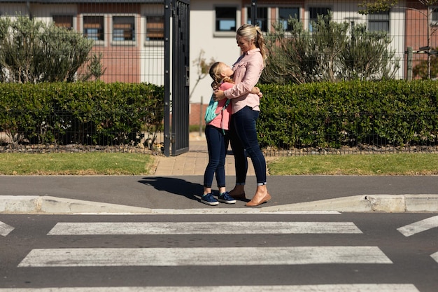 Aluna caucasiana e sua mãe se abraçando