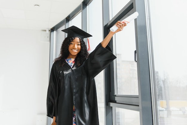 Aluna de pós-graduação afro-americana alegre com um diploma na mão