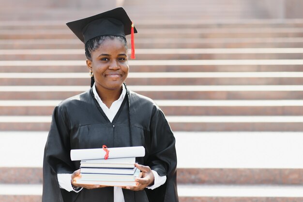 Aluna de pós-graduação afro-americana alegre com um diploma na mão