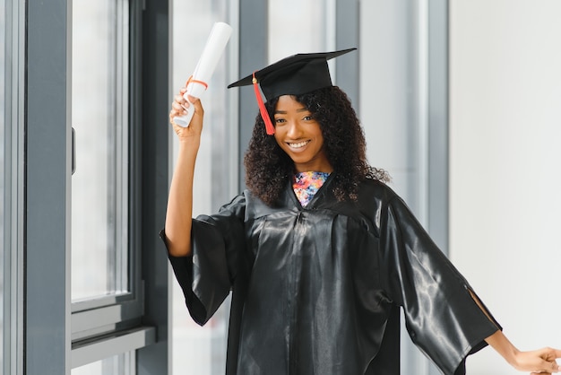 Aluna de pós-graduação afro-americana alegre com um diploma na mão