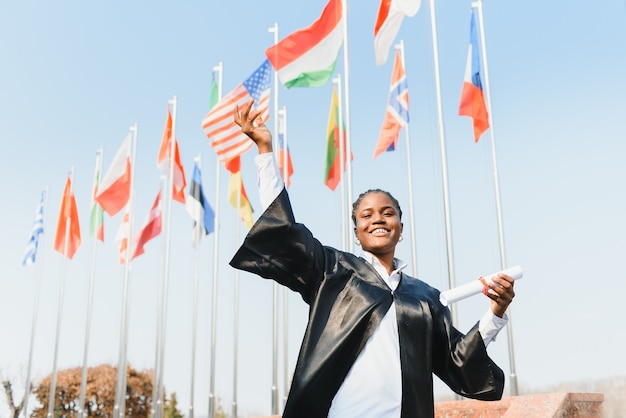 Aluna de pós-graduação afro-americana alegre com um diploma na mão