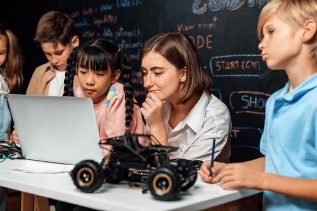 Foto aluna de roupa rosa usa laptop para codificar enquanto o professor observa sua erudição