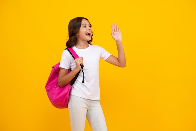 Aluna de uniforme escolar com mochila escolar Estudante adolescente segura mochila em fundo amarelo isolado