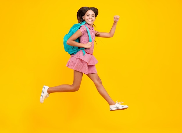 Aluna de uniforme escolar com mochila Estudante adolescente na escola de fundo amarelo isolado