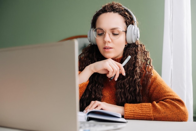 Aluna em home office aprendendo e trabalhando no laptop jovem envolvida em aprendizado remoto