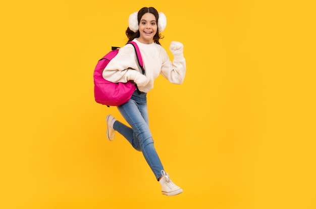 Aluna engraçada da escola com mochila e chapéu de aviso isolado de fundo amarelo Aprendizagem