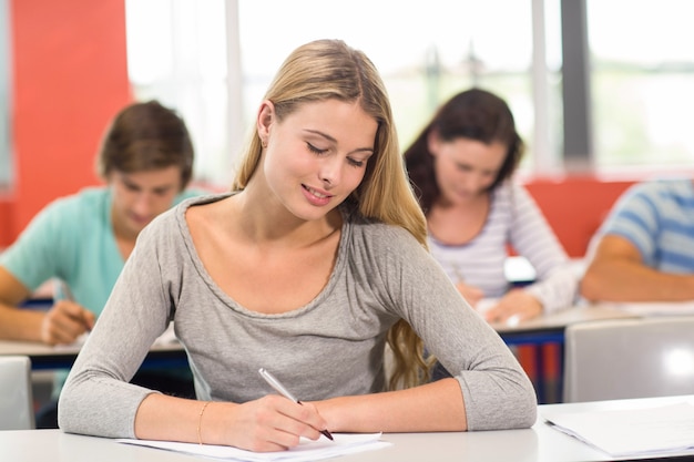 Aluna escrevendo notas em sala de aula