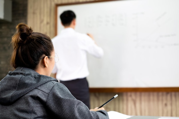 Aluna está sentada na sala de aula e ouvindo atentamente o professor