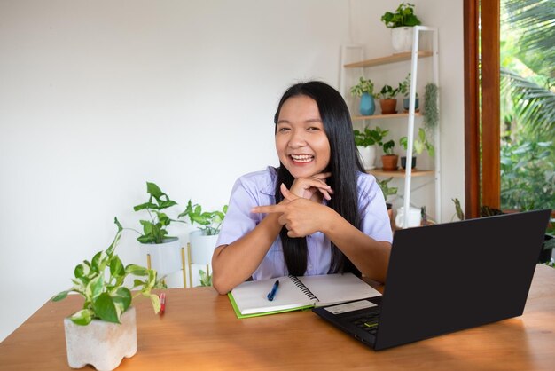 Aluna estuda por slfe no laptop na sala