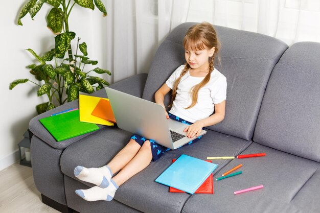 Aluna estudando em casa usando o laptop. Escola em casa, educação online, educação em casa, conceito de quarentena - Imagem