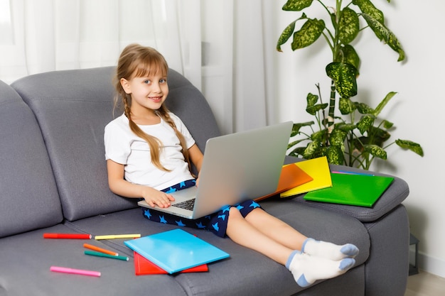 Aluna estudando em casa usando o laptop. Escola em casa, educação online, educação em casa, conceito de quarentena - Imagem