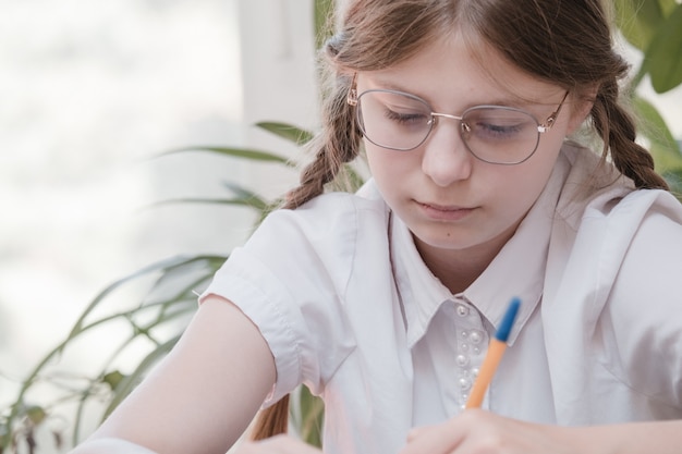 Aluna estudando na escola. passatempo doméstico. menina criança sorridente pintando em casa. ser educado pelo professor vs aprender e estudar em casa com os pais. jovem fazendo lição de casa.