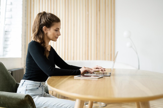 Foto aluna estudando on-line usa aluguel de espaço de coworking para laptop