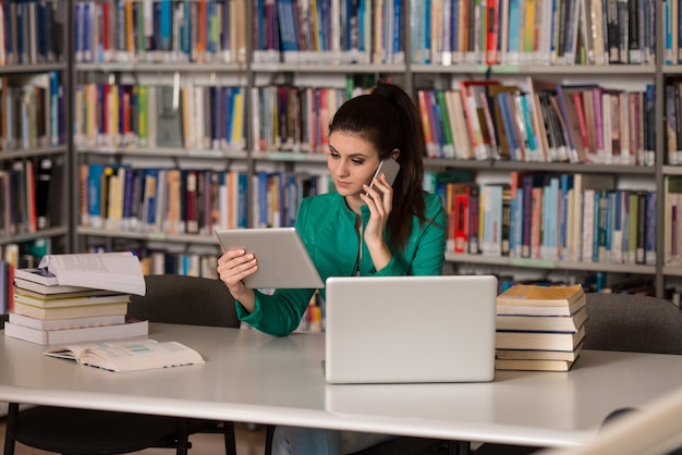 Aluna falando ao telefone na biblioteca Profundidade de campo rasa