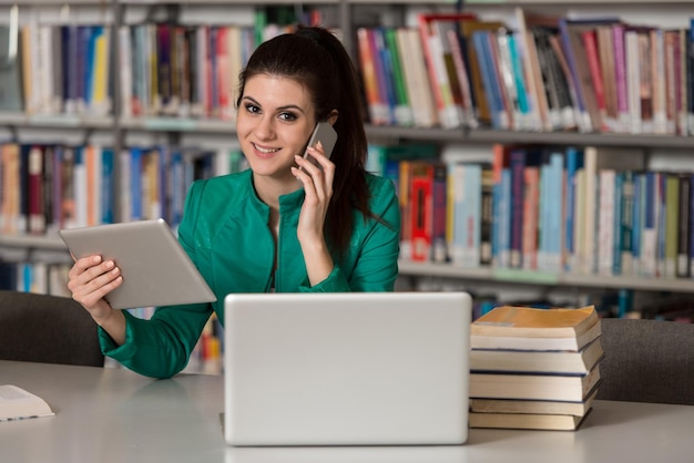 Aluna falando ao telefone na biblioteca Profundidade de campo rasa