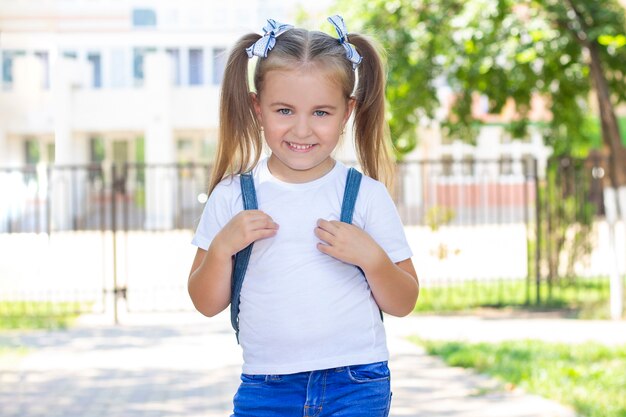 Aluna feliz com uma mochila. em uma camiseta branca