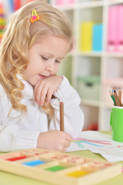 Aluna feliz desenhando com lápis coloridos em casa