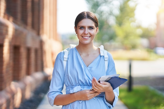 aluna feliz no campus estudando ao ar livre