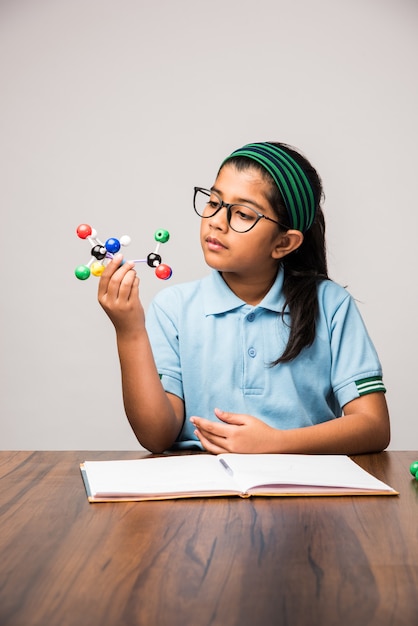 Aluna indiana usando o kit de modelo molecular para estudar ciências, foco seletivo