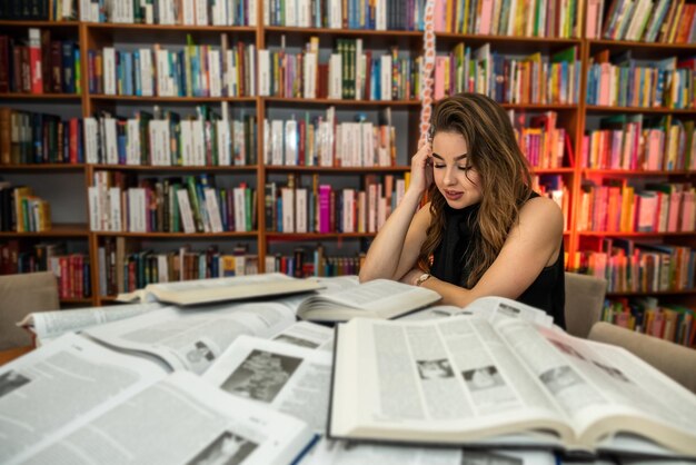 Foto aluna lendo livro no conceito de educação da biblioteca universitária