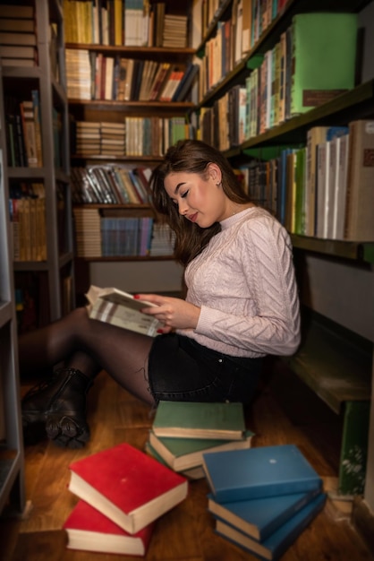 Aluna lendo livro no conceito de educação da biblioteca universitária