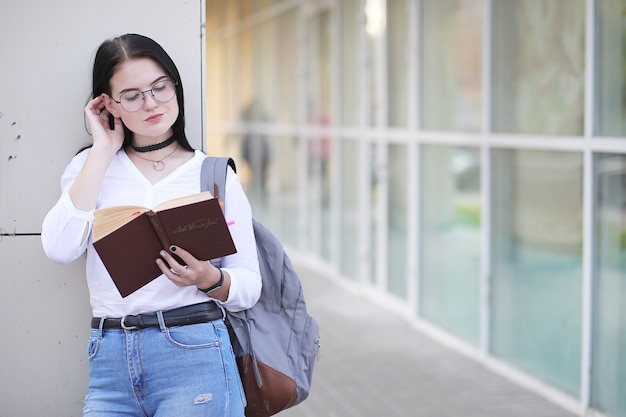 Aluna na rua com uma mochila e livros