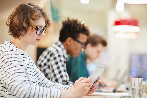 Aluna pensativa usando tablet na Universidade