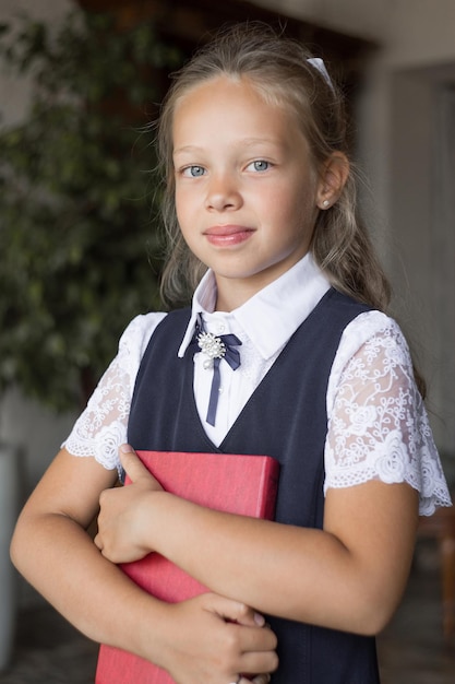 Aluna primária em uniforme escolar com um livro