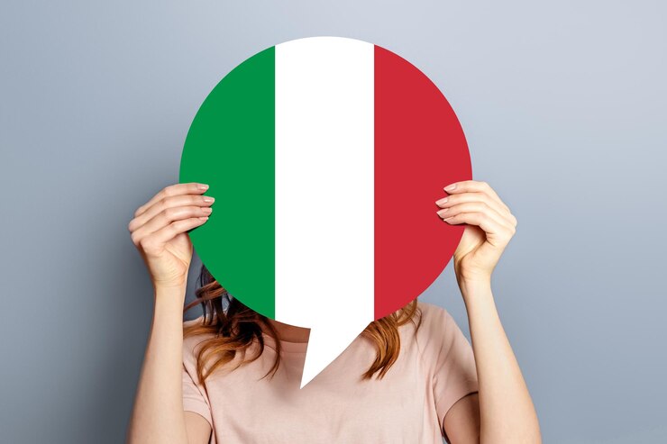 Foto aluna segura balão branco em branco com bandeira italiana isolada sobre fundo de estúdio cinza mulher segurando um pedaço de diálogo de informação redondo