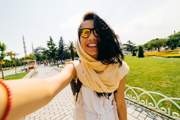 Aluna sorridente de óculos fazendo selfie