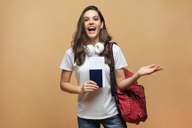 Aluna sorridente em uma viagem isolada em fundo bege.