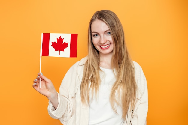 aluna sorrindo e segurando uma pequena bandeira do Canadá