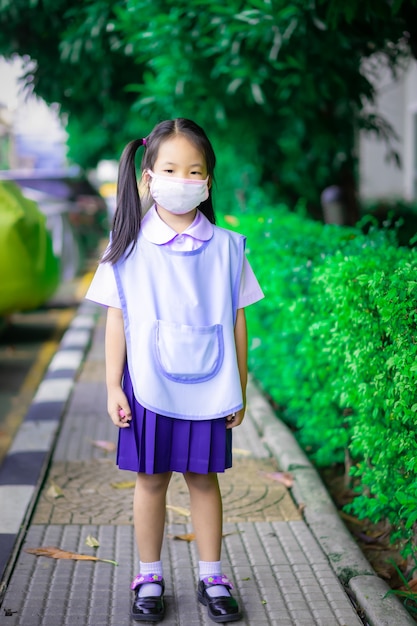 Aluna tailandesa usando uma máscara de proteção antes de ir para a escola