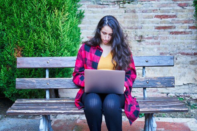 Aluna universitária estudando com laptop no parque