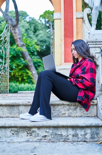 Aluna universitária estudando com laptop no parque