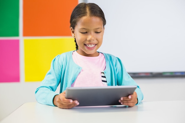 Aluna usando tablet digital em sala de aula