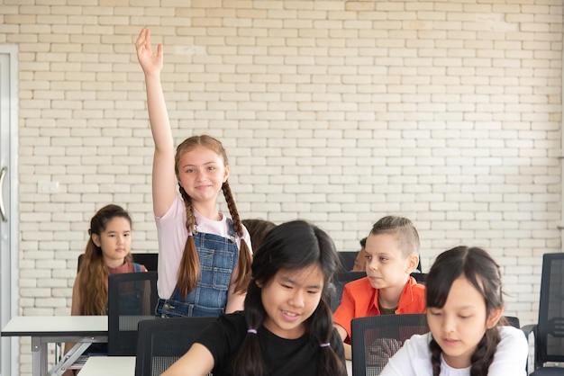 Alunas do ensino fundamental se levantam e levantam as mãos para perguntar ao professor da turma