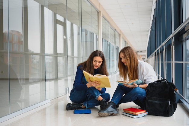 Alunas sentadas no chão lendo notas antes do exame