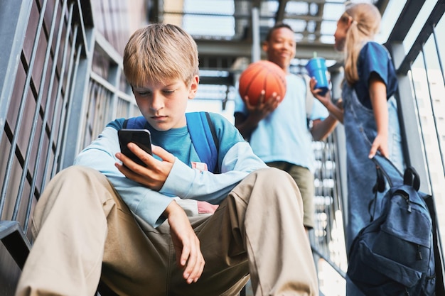 Aluno adolescente com mochila rolando no smartphone