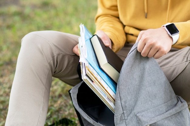 Aluno coloca livros e livros na mochila