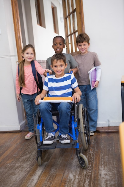 Foto aluno com deficiência com seus amigos em sala de aula