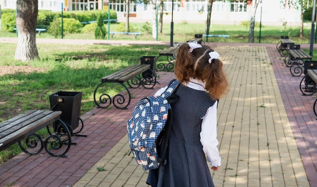 Aluno com mochila e uniforme escolar na escola