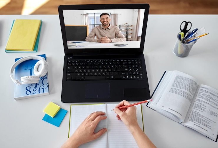 Foto aluno com portátil a ter aulas online em casa