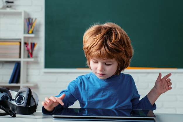 Aluno com tablet digital na sala de aula da escola menino brincando com tablet digital