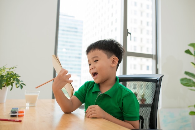 Aluno da ásia estudando e fazendo a lição de casa em casa, na mesa, educação em casa, pensando em ação