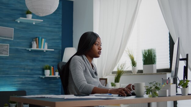 Aluno de pele negra navegando informações sobre a universidade de ensino médio usando o computador